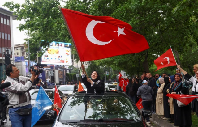 Supporters of Turkish President Tayyip Erdogan react following early exit poll results for the second round of the presidential election outside the provincial headquarters of AK Party (AKP) in Istanbul