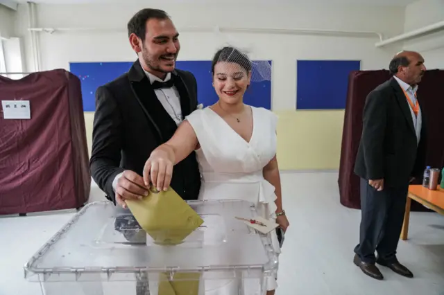 A bride and groom cast their vote