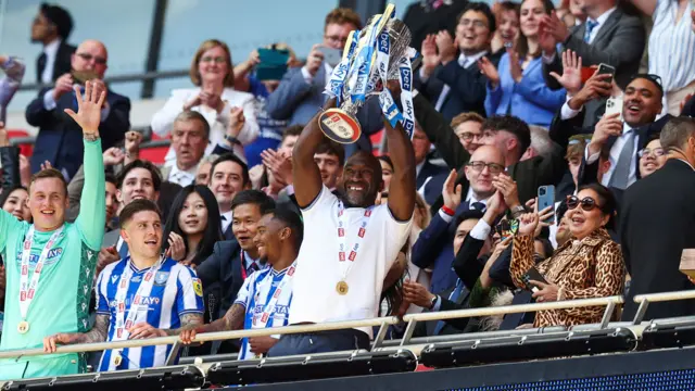 Darren Moore lifts the trophy