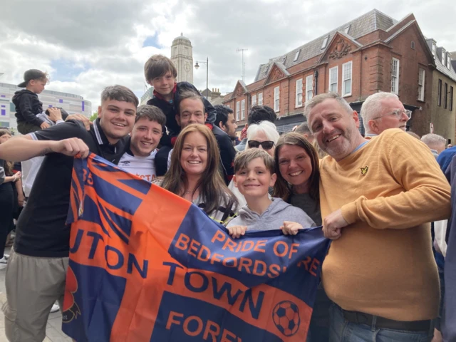 People holding a Luton Town flag