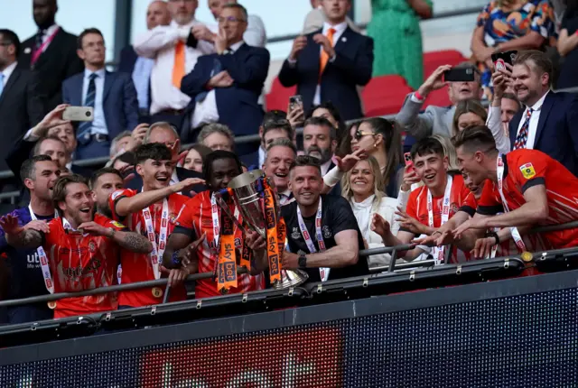 Luton Town manager Rob Edwards lifts the trophy with the team after winning promotion to the Premier League after the Sky Bet Championship play-off final at Wembley Stadium, London