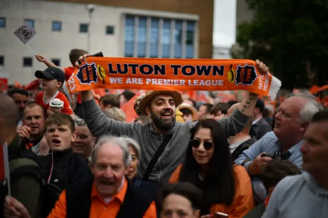 A Luton Town fan holding a scarf