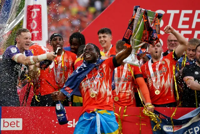 Luton Town’s Elijah Adebayo celebrates with the trophy after the Sky Bet Championship play-off final at Wembley Stadium, London