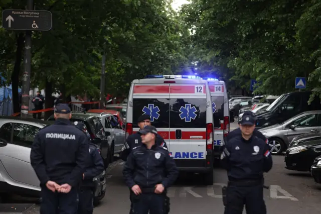 Ambulance cars arrive at the site as police officers block a street near the Vladislav Ribnikar elementary school in Belgrade, Serbia