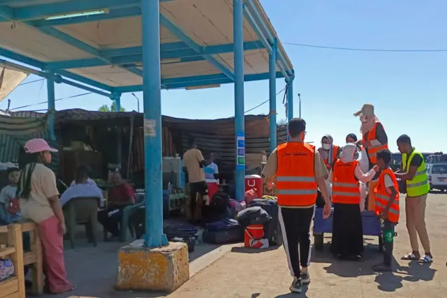 Volunteers prepare aid packages for refugees fleeing war-torn Sudan, at the Wadi Karkar bus station near the Egyptian city of Aswan, on May 2, 2023