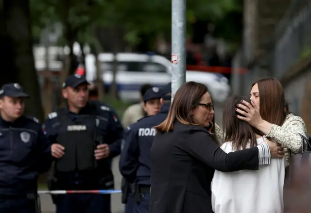 Teachers of Vladislav Ribnikar elementary school console students as police cordon off the area