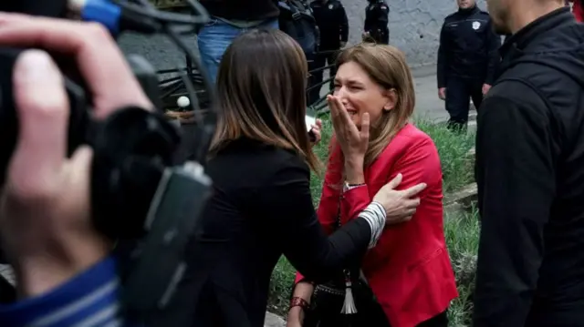 Woman pictured holding her hand to her face and crying