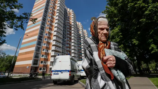 An elderly woman stands in from of a damaged residential building following a reported drone attack in Moscow, Russia, 30 May 2023.