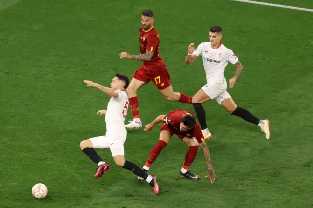 Lucas Ocampos of Sevilla goes down in the box after a challenge from Roger Ibanez