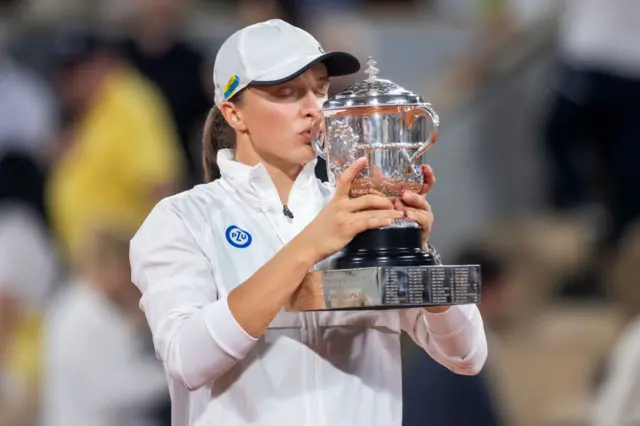 Iga Swiatek kisses the French Open trophy in 2022