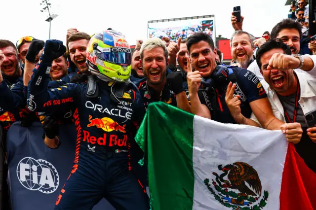 Sergio Perez celebrates with his Red Bull crew, holding a Mexican, after winning in Baku