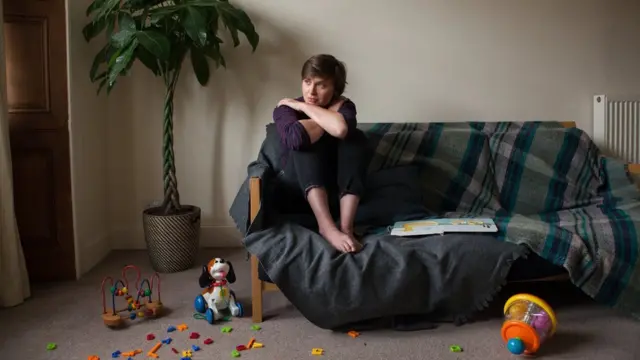 Woman sits on couch