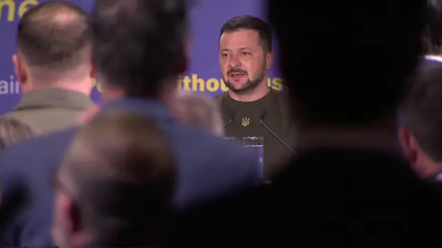 People applaud as Volodymyr Zelensky ends his speech