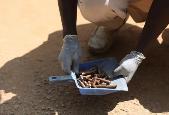 A member of the Nigerian Forensic team picks shells of bullet from the scene of where unknown gunmen suspected to be Boko Haram terrorist attack the Kuje Medium Prison in Abuja, Nigeria on July 6, 2022