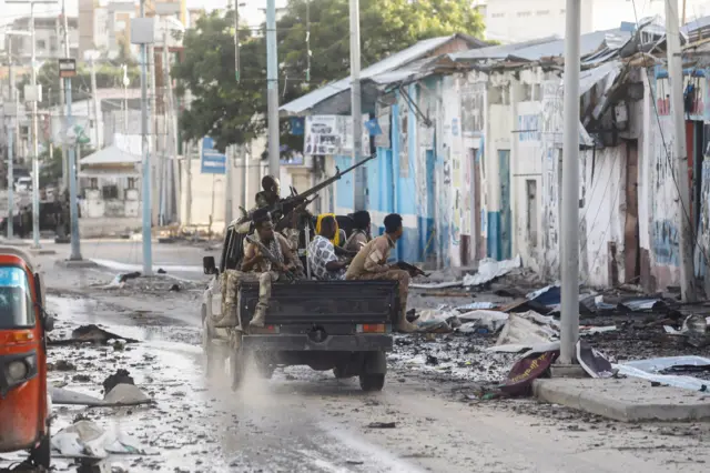 Somali security officers drive past a section of Hotel Hayat, the scene of an al Qaeda-linked al Shabaab group militant attack in Mogadishu, Somalia August 20, 2022.