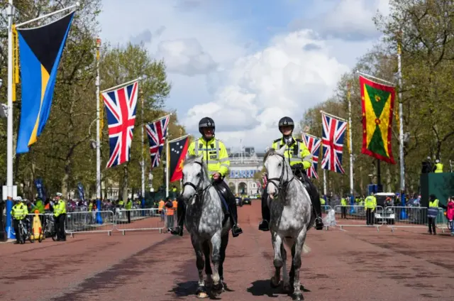 Police officers ride horses at the Mall outside Buckingham Palace