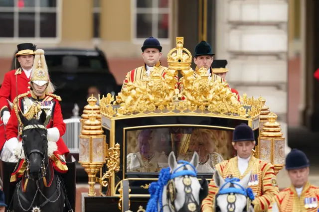 King Charles III and Queen Camilla are carried in the Diamond Jubilee State Coach