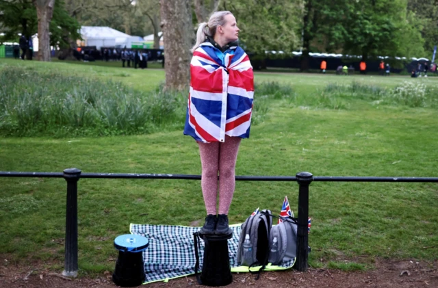 Woman stands on a bollard in central London