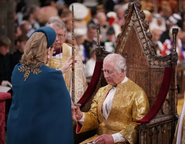 The Lord President of the Council, Penny Mordaunt, presenting the Sword of State, to King Charles III during his coronation ceremony in Westminster Abbey, London.