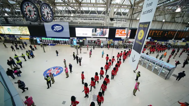 Members of the armed forces taking part in the coronation processions file into Waterloo station in London