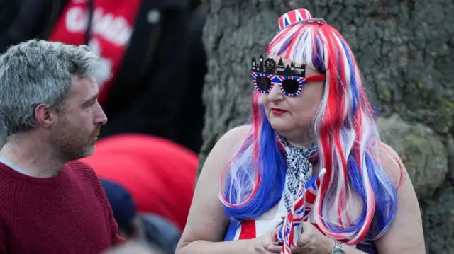 A woman in a red white and blue wig and London landmark glasses