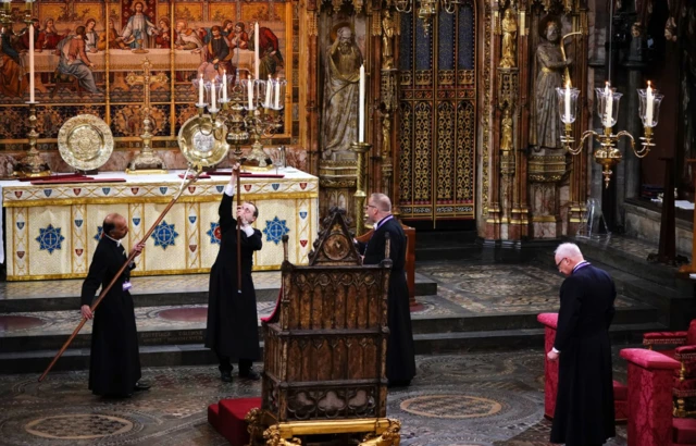 Preparations continue inside the Abbey as candles are lit above the chair where Charles will be crowned King