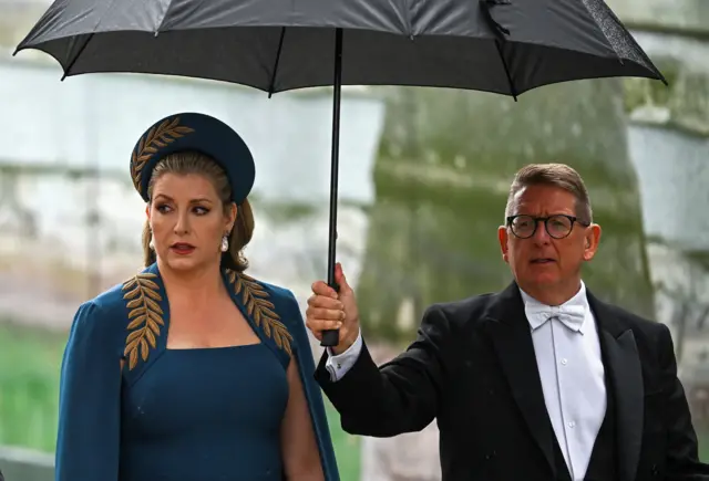 Penny Mordaunt walking with an umbrella