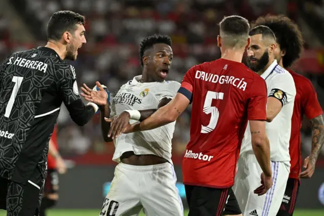 Real Madrid's Brazilian forward Vinicius Junior (C,L) discusses with Osasuna's Spanish defender David Garcia during the Spanish Copa del Rey (King's Cup) final football match between Real Madrid CF and CA Osasuna at La Cartuja stadium in Seville on May 6, 2023.