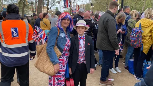 10-year-old Hudson wears a union jack waistcoat and bow tie next to his mother, who wears a red, white and blue wig and a union jack dress