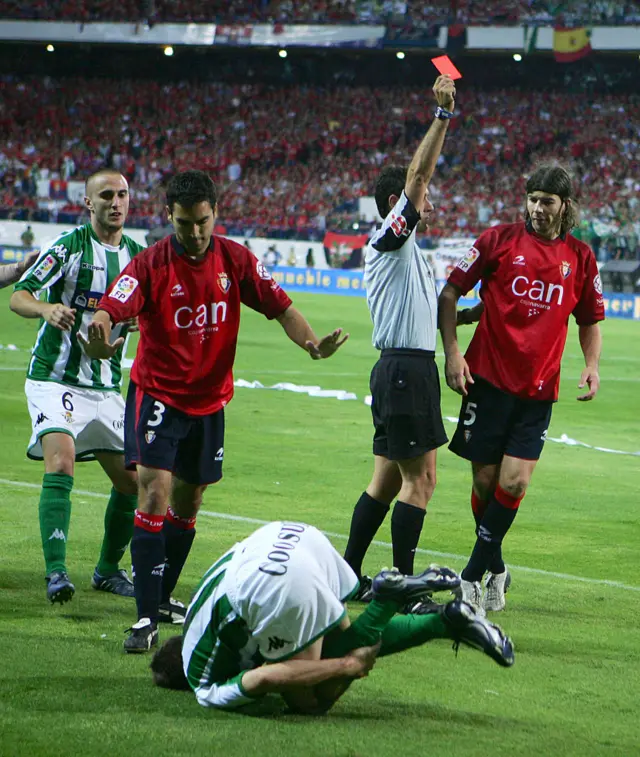 Referee Alfonso Perez gives Pablo Garcia #5 of Osasuna the red card after he fouled Sanchez Joaquin #17 of Real Betis (foreground) in a Kings Cup final between Real Betis and Osasuna on June 11, 2005 at the Calderon Stadium in Madrid, Spain.