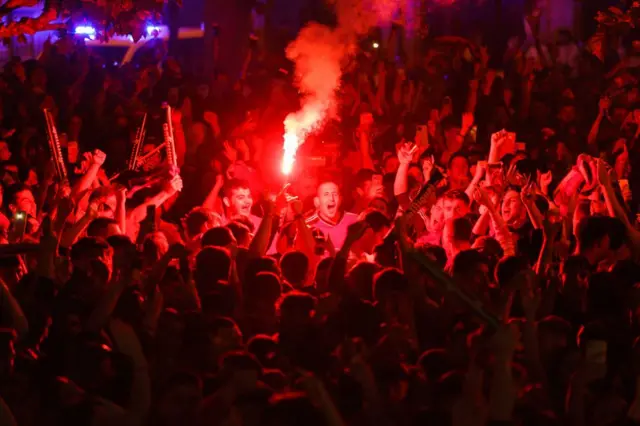 Osasuna's supporters cheer and light flares after a goal on the Plaza del Castillo in downtown Pamplona during the Spanish Copa del Rey (King's Cup) final football match between Osasuna and Real Madrid on May 6, 2023.