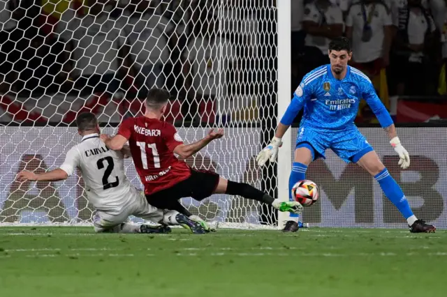 Osasuna's Spanish forward Kike Barja (C) fights for the ball with Real Madrid's Spanish defender Dani Carvajal (L) and Real Madrid's Belgian goalkeeper Thibaut Courtois during the Spanish Copa del Rey (King's Cup) final football match between Real Madrid CF and CA Osasuna at La Cartuja stadium in Seville on May 6, 2023