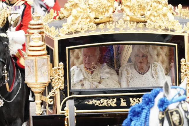 King Charles III and Queen Camilla are carried in the Diamond Jubilee State Coach