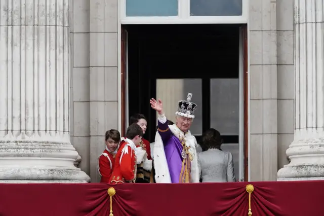 The King waves as he heads in again after waving from the balcony