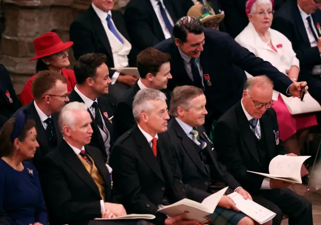 A guest takes pictures with Anthony McPartlin and Declan Donnelly ahead of the coronation of King Charles III and Queen Camilla at Westminster Abbey, London.