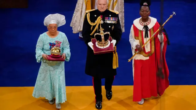 Dame Elizabeth Anionwu (L) carrying the orb - 6 May 2023