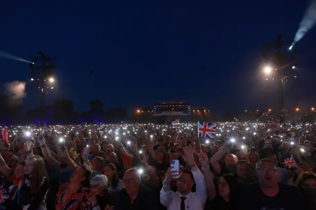 Audience using their cell phones' lights watching the concert