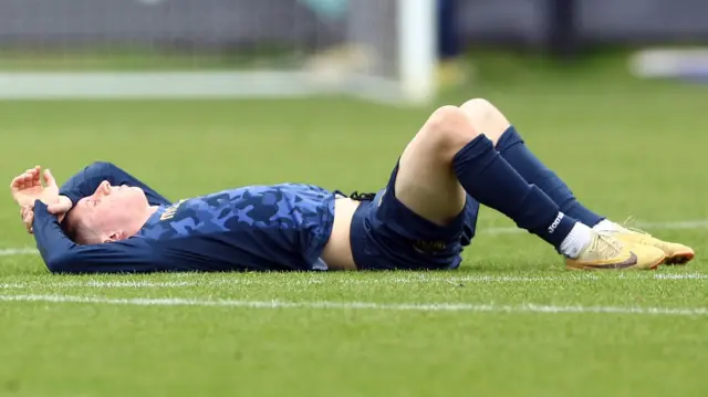 A Morecambe player lies on the floor after their relegation is confirmed