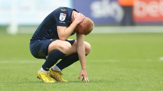 Morecambe's Liam Gibson is dejected after his side are relegated