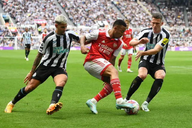 Gabriel Jesus of Arsenal is challenged by Bruno Guimaraes of Newcastle United and Sven Botman of Newcastle United