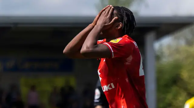 MK Dons' Paris Maghoma holds his head in his hands