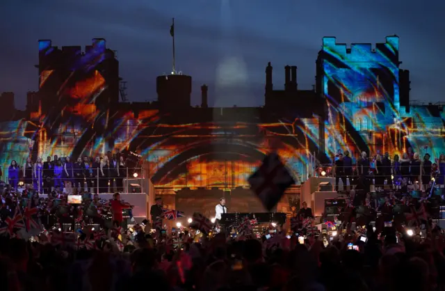 Lionel Richie performing on the stage with the colorful lights