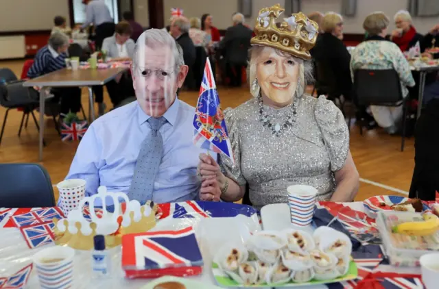 People take part with royal masks in a Big Lunch in Doagh, Northern Ireland