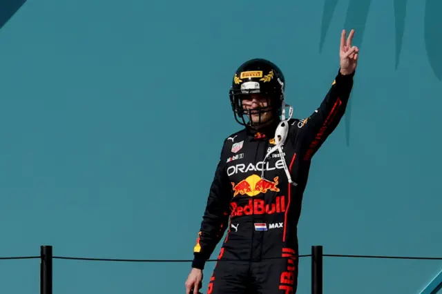 Max Verstappen wears an American football helmet on the podium in Miami in 2022