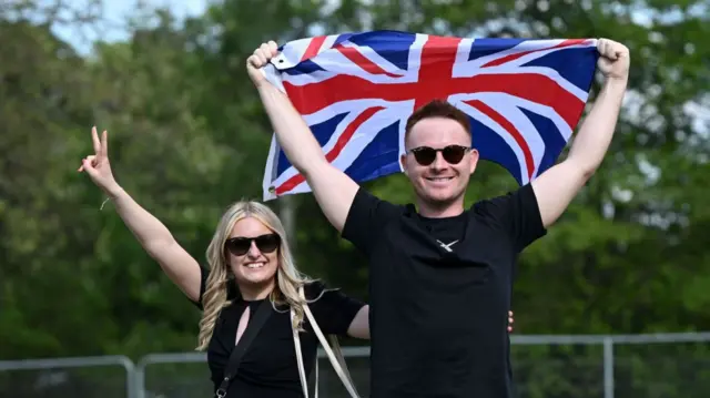 Members of the public pose as they arrive to take their seats for the Coronation Concert held in the grounds of Windsor Castle