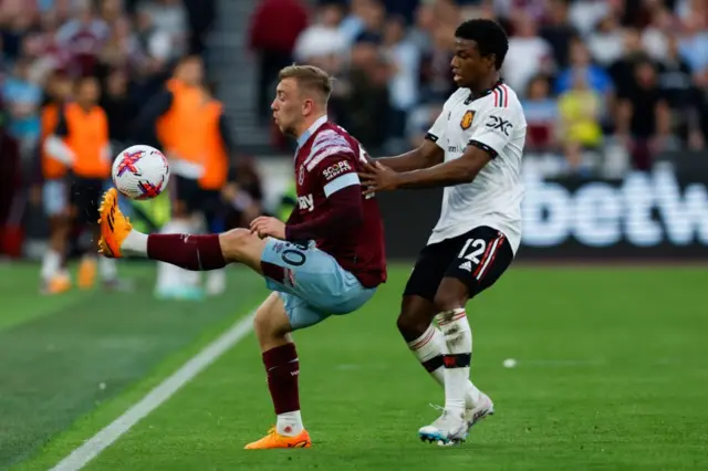 arrod Bowen (L) fights for the ball with Manchester United's Dutch defender Tyrell Malacia