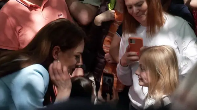 The Princess of Wales talks to a young girl in the crowd