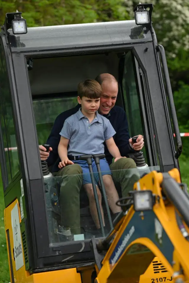 The Prince of Wales and Prince Louis sit on a digger as part of the Big Help Out in Upton Scouts Hut in Slough