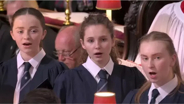 Three schoolgirls singing in Westminster Abbey