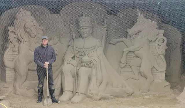 Mark Anderson in front of his sand sculpture of the King on Weymouth Beach